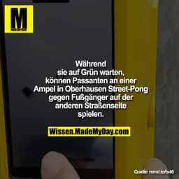 Während sie auf Grün warten, können Passanten an einer Ampel in Oberhausen Street-Pong gegen Fußgänger auf der anderen S
