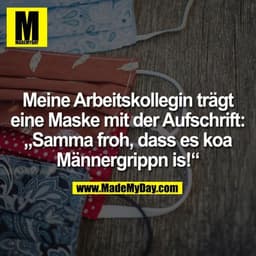 Meine Arbeitskollegin trägt eine Maske mit der Aufschrift: „Samma froh, dass es koa Männergrippn is!“